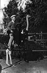 Grant Keyes Chapman, riding on an ostrich, 1928
