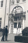 Installing letters over entrance to Founders' Hall, Chapman College, Orange, California, 1968