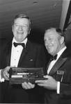 John Wayne and Clement L. Hirsch admire one of two antique pistols presented to the actor at the Challenge '70 Dinner