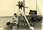 Berndt with 16mm motion picture camera and equipment, on a boat